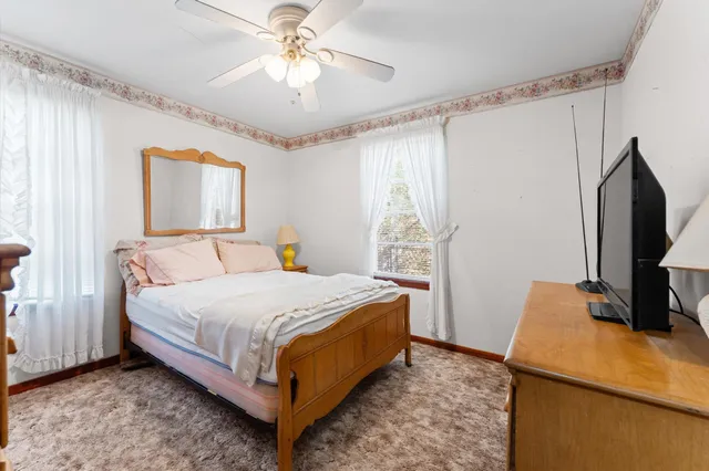 a bedroom with a bed and a flat tv screen on dresser