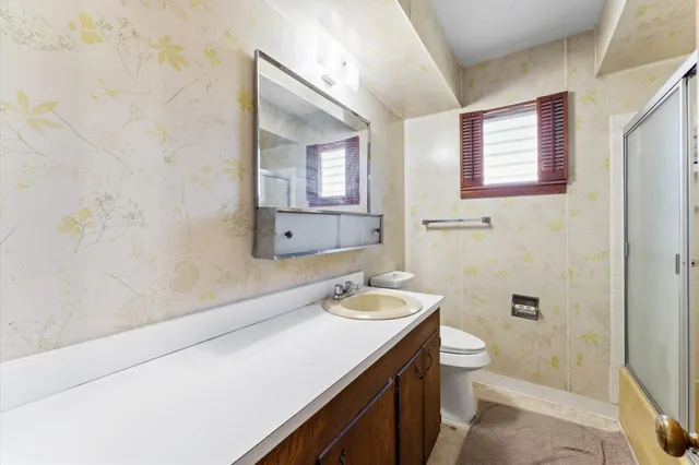 a bathroom with a sink a toilet and shower