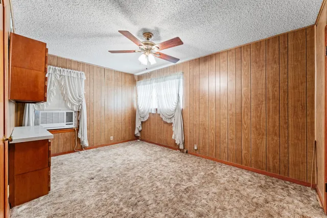 a view of an empty room with window and cabinet