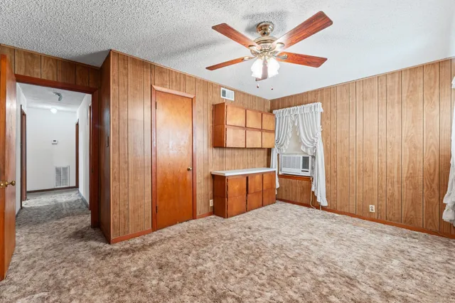 an empty room with closet and windows