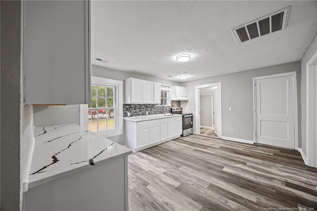 1601 Camden Road Fayetteville, NC 28306 - Photo 4 of 31 a kitchen with granite countertop white cabinets and white appliances