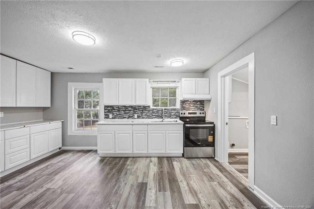 1601 Camden Road Fayetteville, NC 28306 - Photo 6 of 31 a kitchen with granite countertop white cabinets and white appliances