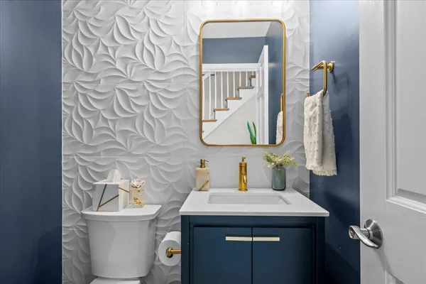 a bathroom with a sink and mirror with toilet