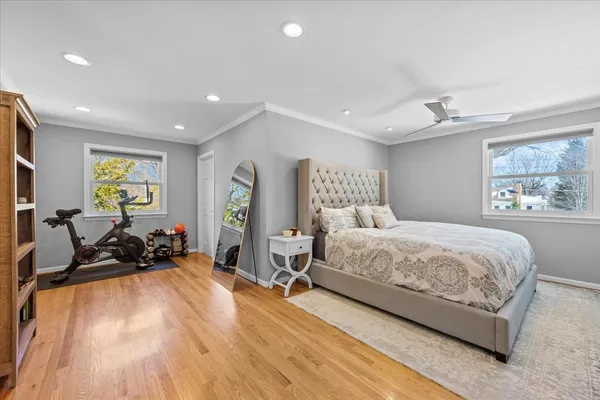 a spacious bedroom with a bed and wooden floor
