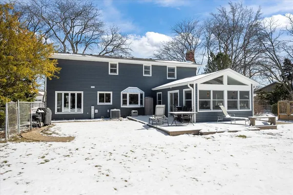 a front view of a house with a yard covered in snow