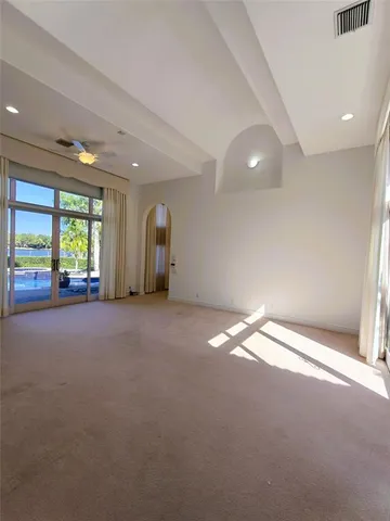 a view of an empty room with a window and a bathroom