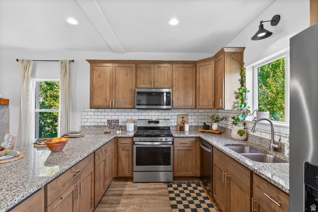 681 Island Road Morgan, UT 84050 - Photo 6 of 49 U-shaped kitchen featuring wood cabinetry, stainless steel appliances, granite countertops, and a subway tile backsplash
