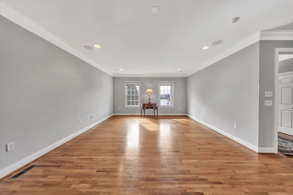 a view of empty room with wooden floor and fireplace