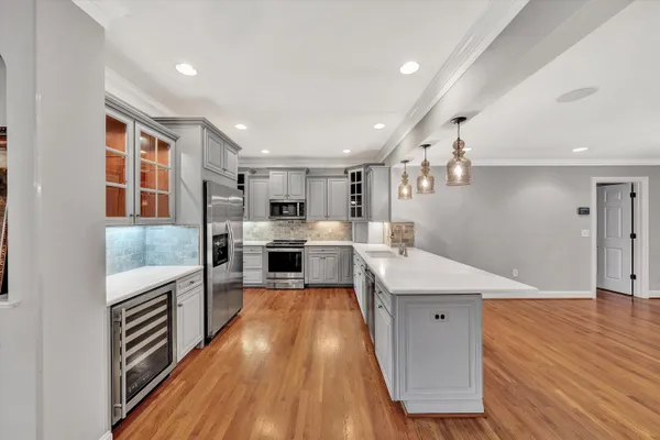 a large kitchen with stainless steel appliances and white cabinets