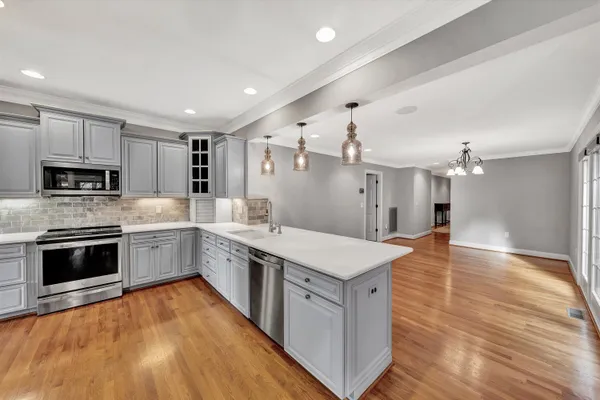 a kitchen with stainless steel appliances kitchen island granite countertop a stove and a refrigerator