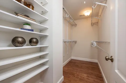 a view of walk in closet with clothes and shoes