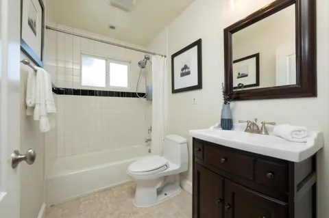 a bathroom with a toilet a sink a mirror and a bathtub
