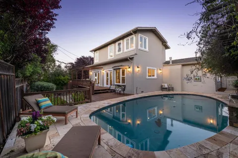 a view of a house with swimming pool and sitting area