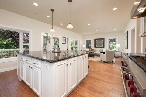 a kitchen with granite countertop a stove and a wooden floors
