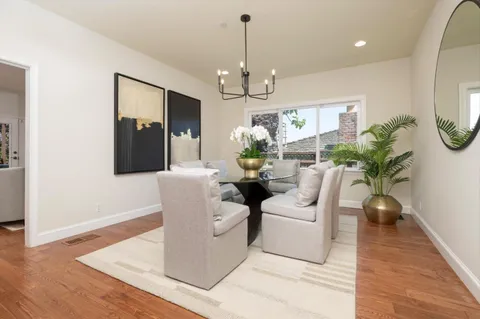 a living room with furniture a chandelier and wooden floor