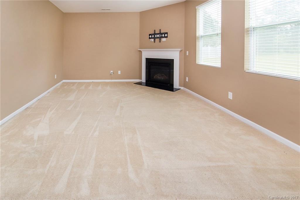 11824 Bending Branch Road Charlotte, NC 28227 - Photo 4 of 23 a view of an empty room with a fireplace and a window