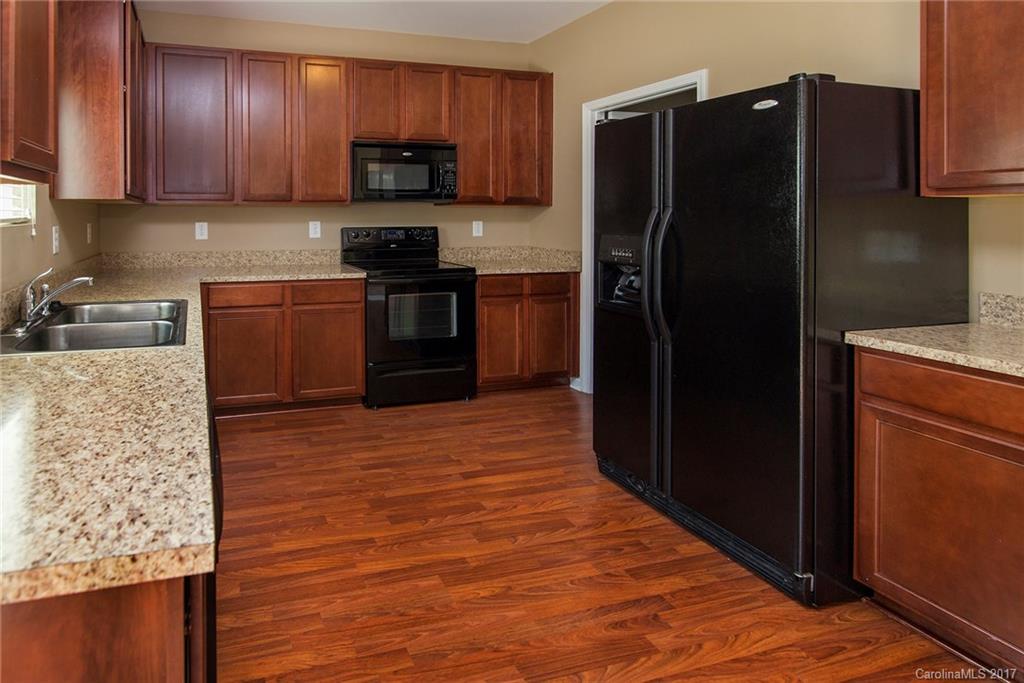 11824 Bending Branch Road Charlotte, NC 28227 - Photo 6 of 23 a kitchen with granite countertop stainless steel appliances and wooden cabinets