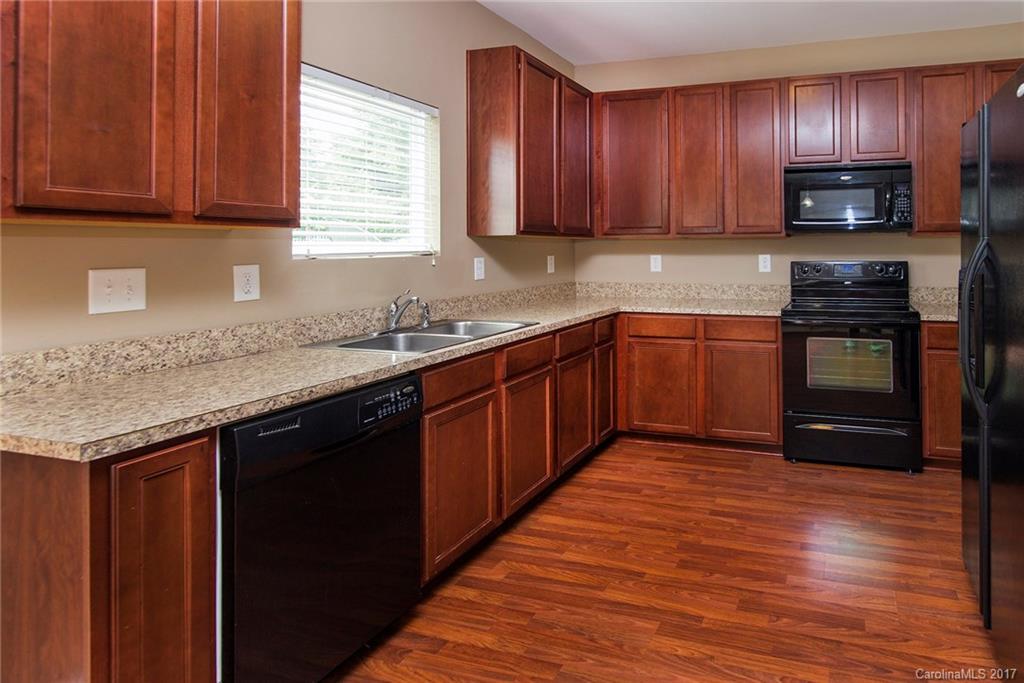 11824 Bending Branch Road Charlotte, NC 28227 - Photo 7 of 23 a kitchen with stainless steel appliances granite countertop wooden cabinets a stove top oven with wooden floor