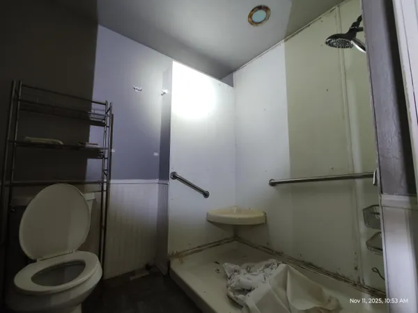 a bathroom with a toilet and a shower