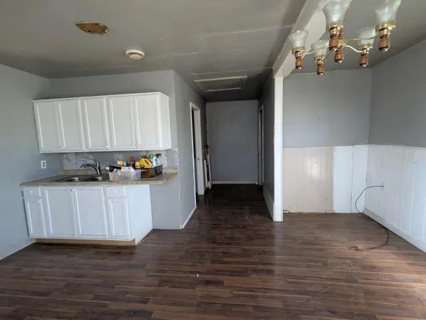 a kitchen with granite countertop white cabinets and wooden floor