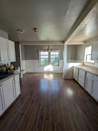 a open kitchen with cabinets and wooden floor
