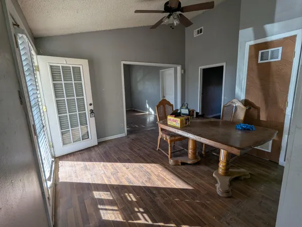 a living room with a table chairs and a wooden floor