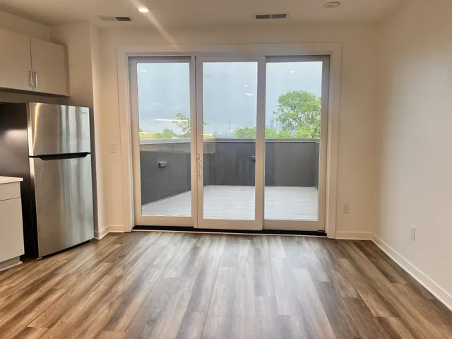 a view of a kitchen with wooden floor and refrigerator