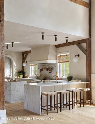 a view of an empty room with wooden floor and windows