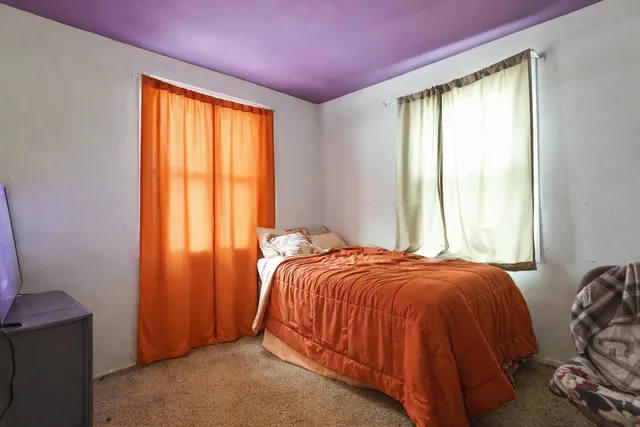 a bed sitting in a bedroom next to a window