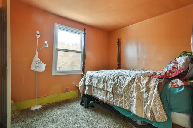 a bed sitting in a bedroom next to a window