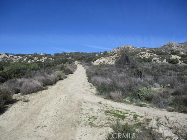 a view of a dry yard with mountains in the background