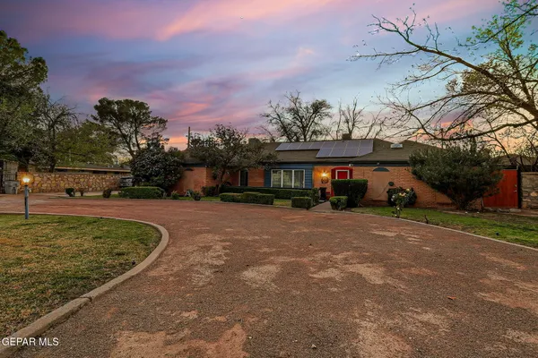 a front view of a house with a yard and mountain view in back
