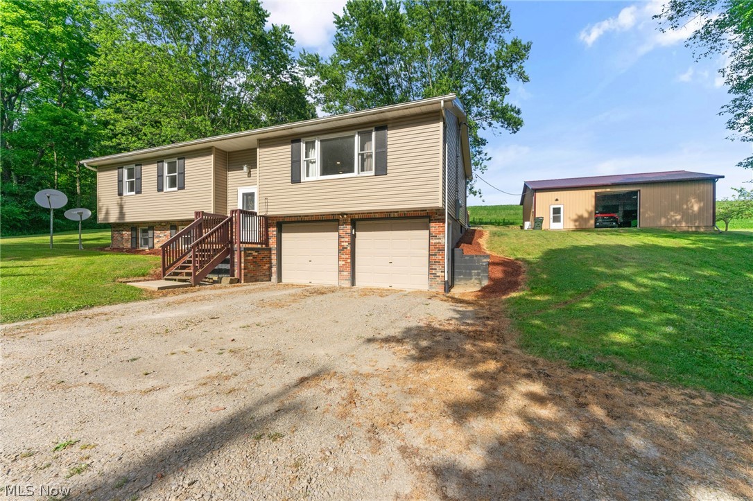 8184 Rochester Road East Rochester, OH 44625 - Photo 1 of 28 Raised ranch featuring a garage and a front lawn
