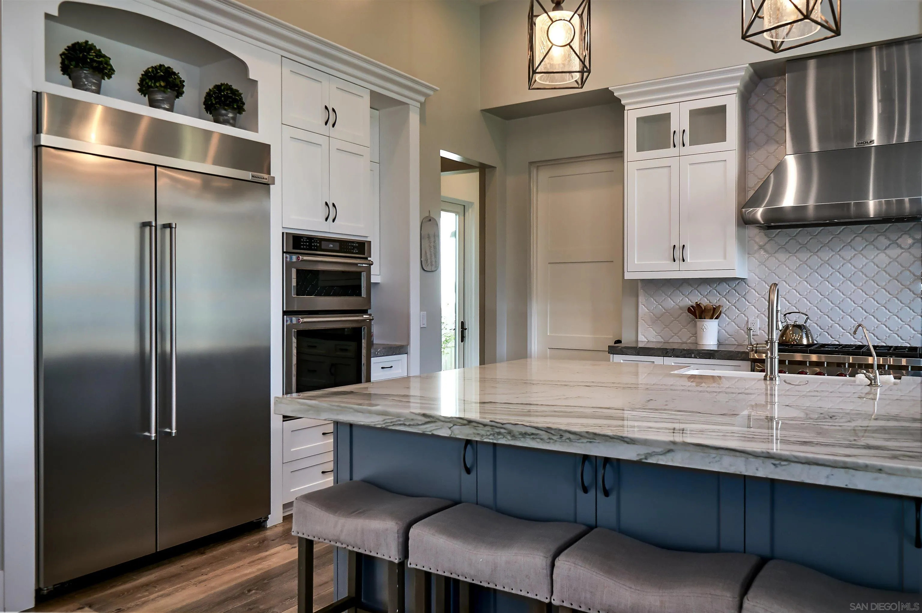 20104 Questhaven Road Elfin Forest, CA 92029 - Photo 18 of 33 a kitchen with stainless steel appliances granite countertop a refrigerator a stove and a sink with wooden floor