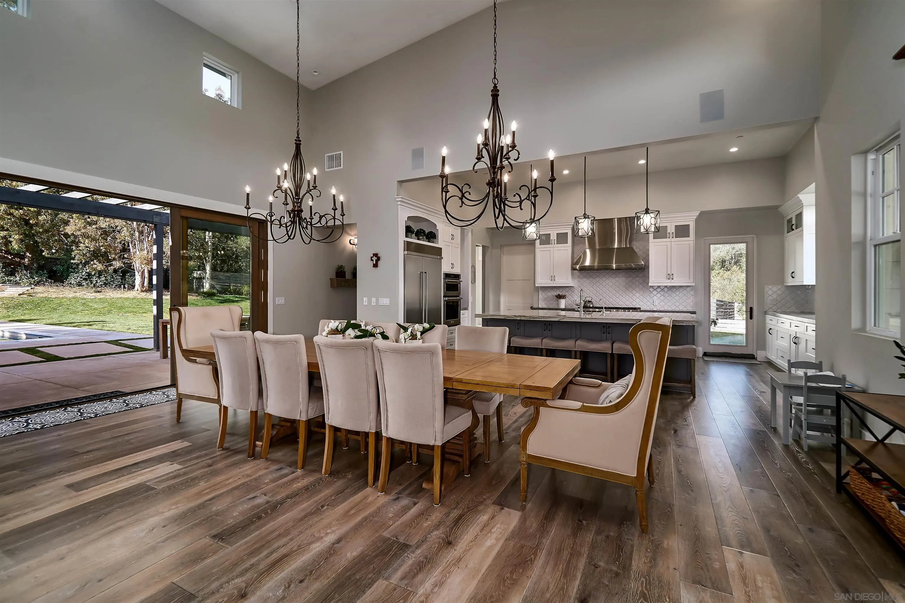 20104 Questhaven Road Elfin Forest, CA 92029 - Photo 19 of 33 a dining room with wooden floor a chandelier a wooden table and chairs