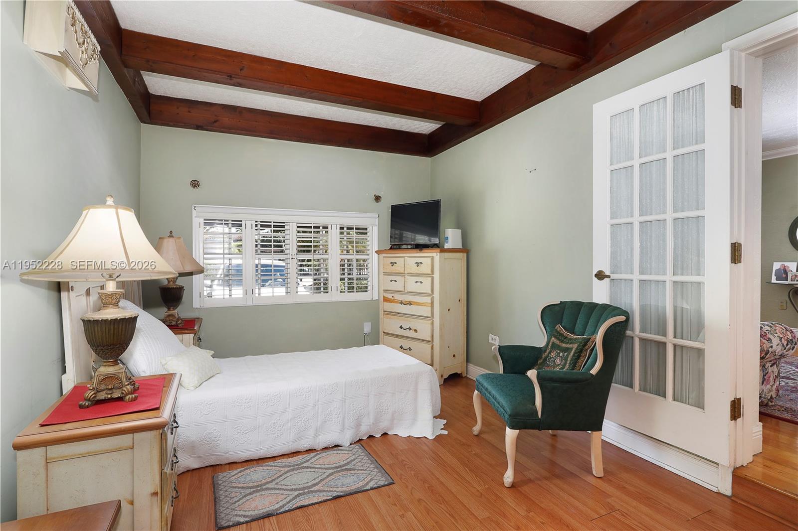 3030 Southwest 57th Avenue Miami, FL 33155 - Photo 6 of 12 a bedroom with a bed and wooden floor