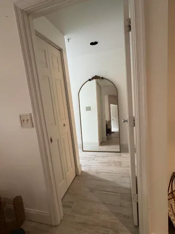 a view of a hallway with wooden floor