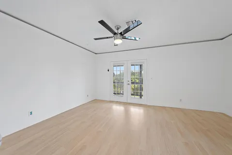 an empty room with wooden floor and windows