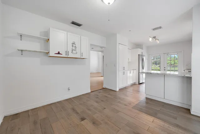 a view of a kitchen with refrigerator and white cabinets