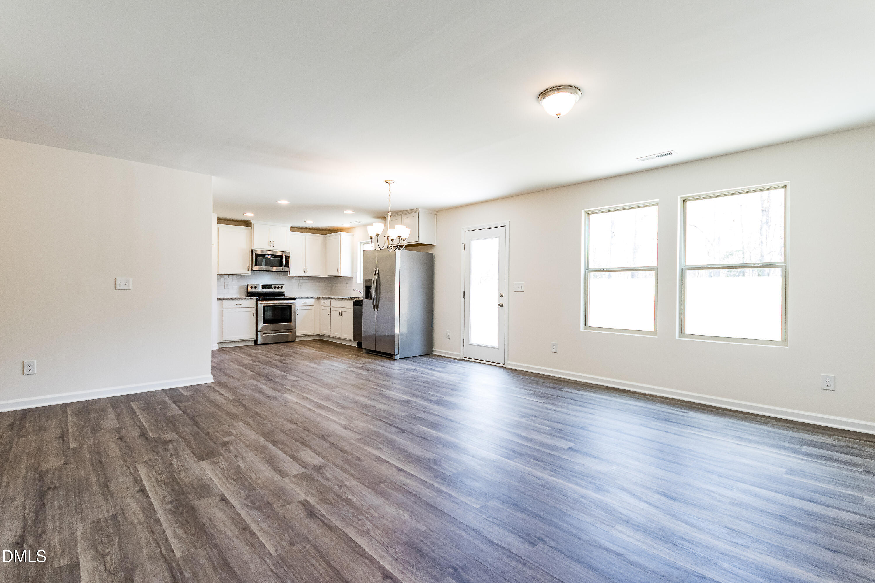 3309 Slippery Elm Drive Raleigh, NC 27610 - Photo 15 of 29 an empty room with wooden floor kitchen stove and windows