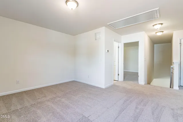a view of a big room with wooden floor and windows