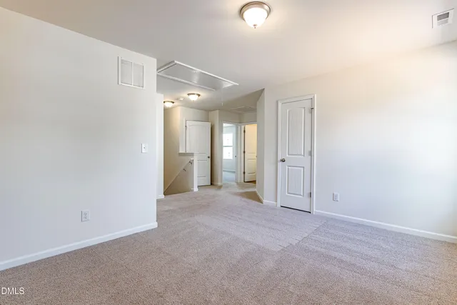 an empty room with entrance and windows