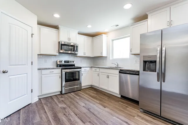 a kitchen with stainless steel appliances a refrigerator sink and microwave