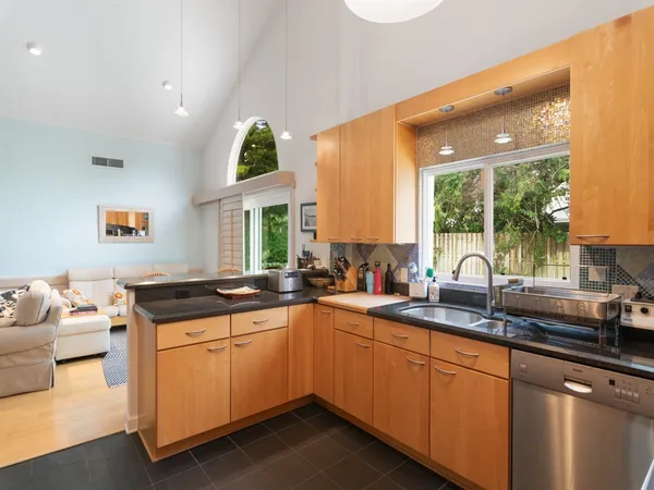 a kitchen with granite countertop a sink and white cabinets