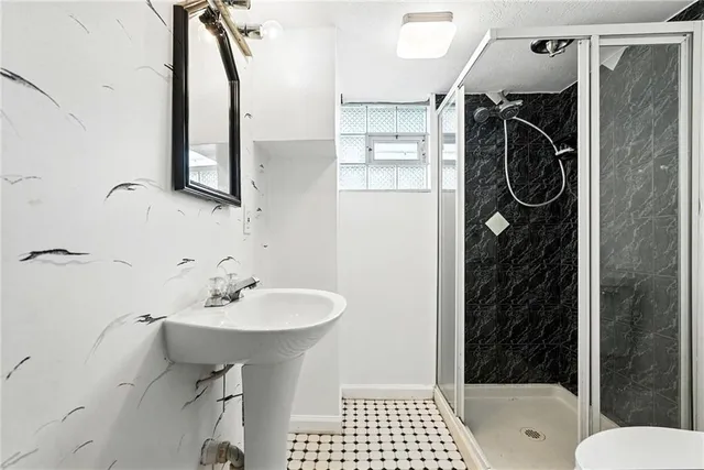 a bathroom with a sink a toilet and shower