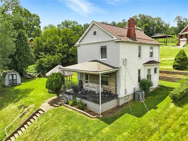 a view of a house with backyard and porch