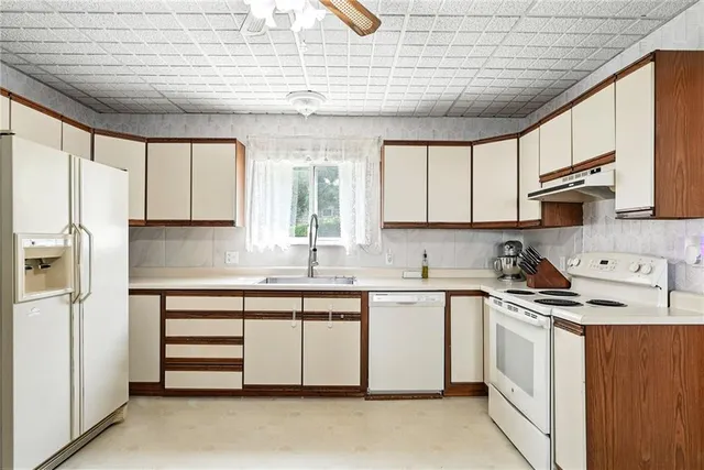 a kitchen with stainless steel appliances granite countertop a sink window and cabinets