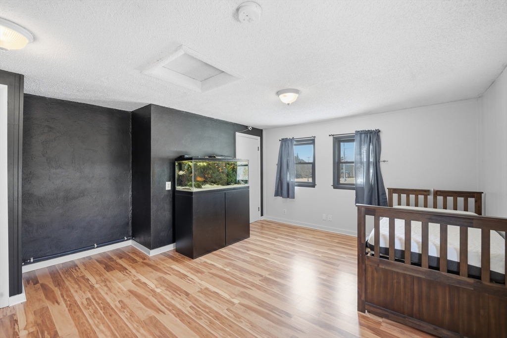 325 Granby Road Chicopee, MA 01013 - Photo 29 of 36 a bedroom with a bed and wooden floor