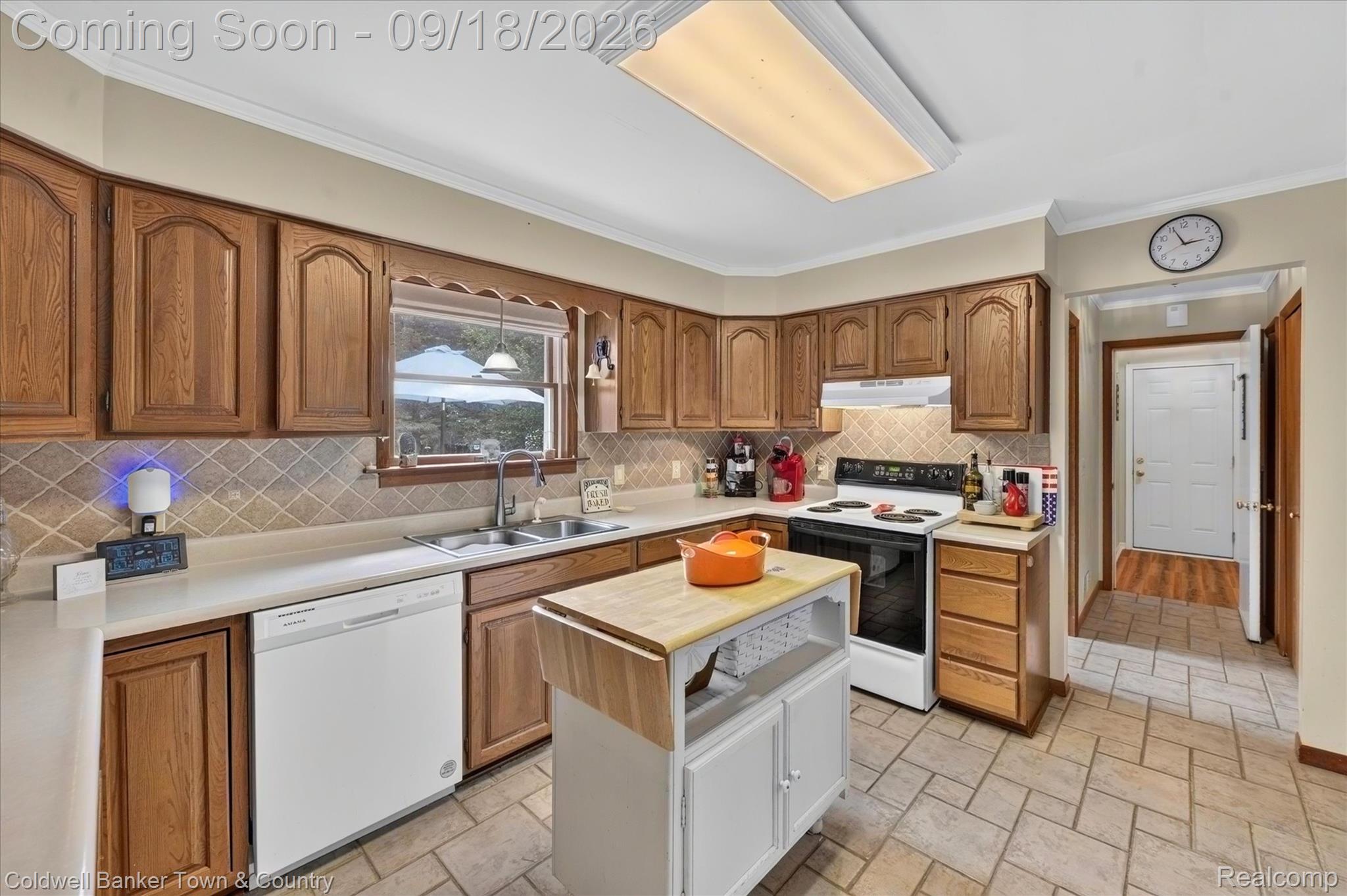 4442 McGunn Road Howell, MI 48843 - Photo 17 of 63 Kitchen featuring wood cabinetry, solid surface countertops, tile backsplash, and tile flooring