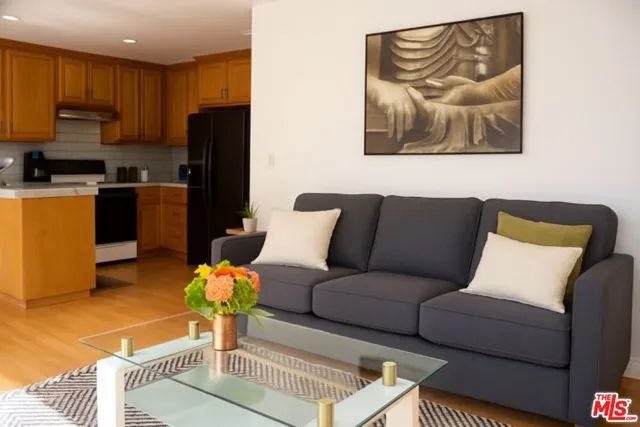 a living room with furniture and a refrigerator